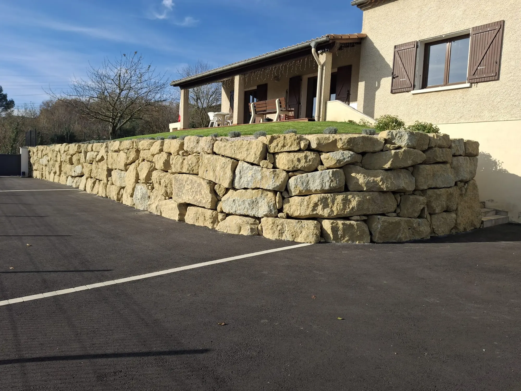 Mur d'enrochement et cour en enrobé devant une maison, réalisation Marson TP dans l'Aude