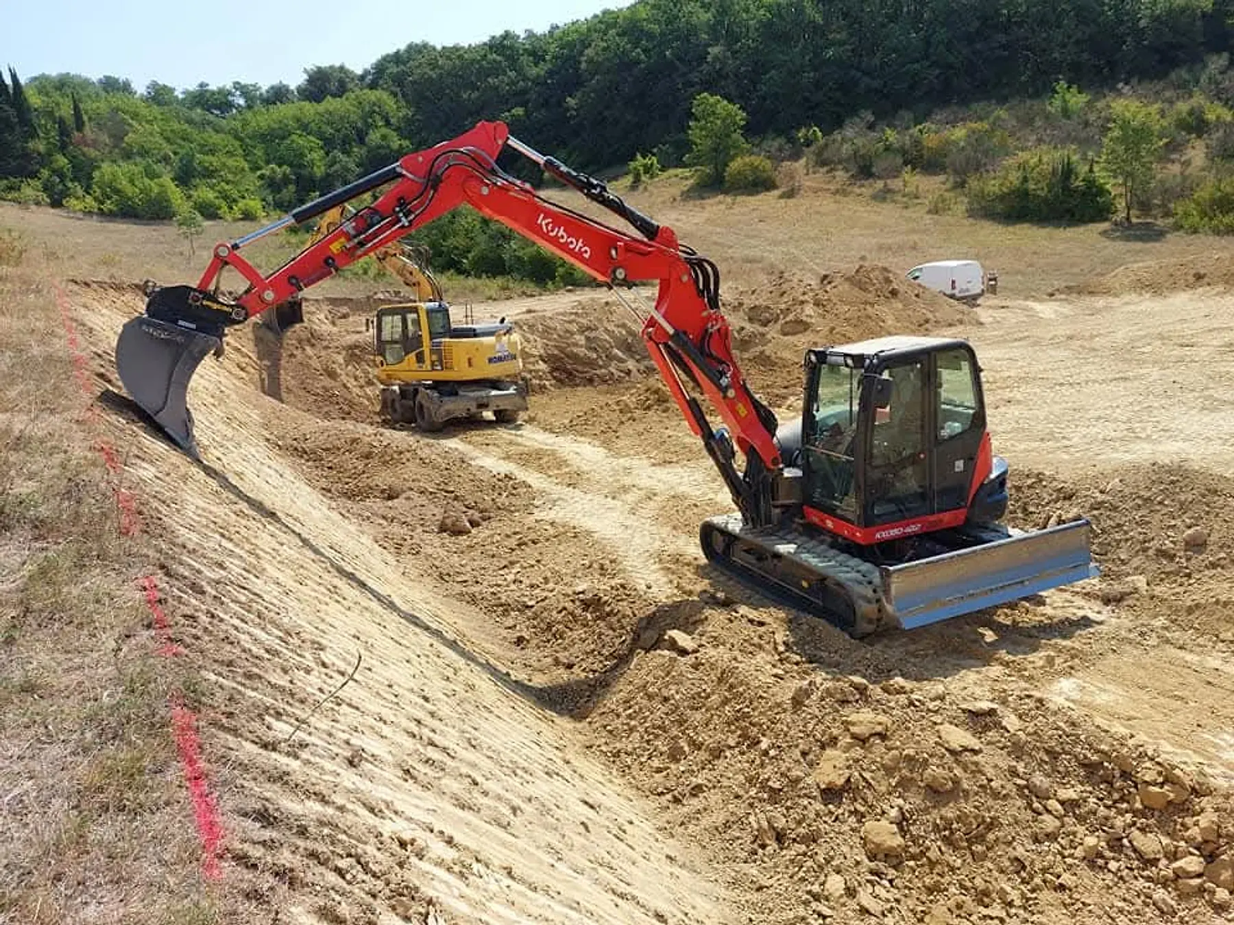 Pelle Kubota de Marson TP taillant un talus, une seconde pelle en arrière-plan, sur un chantier de terrassement dans l'Aude